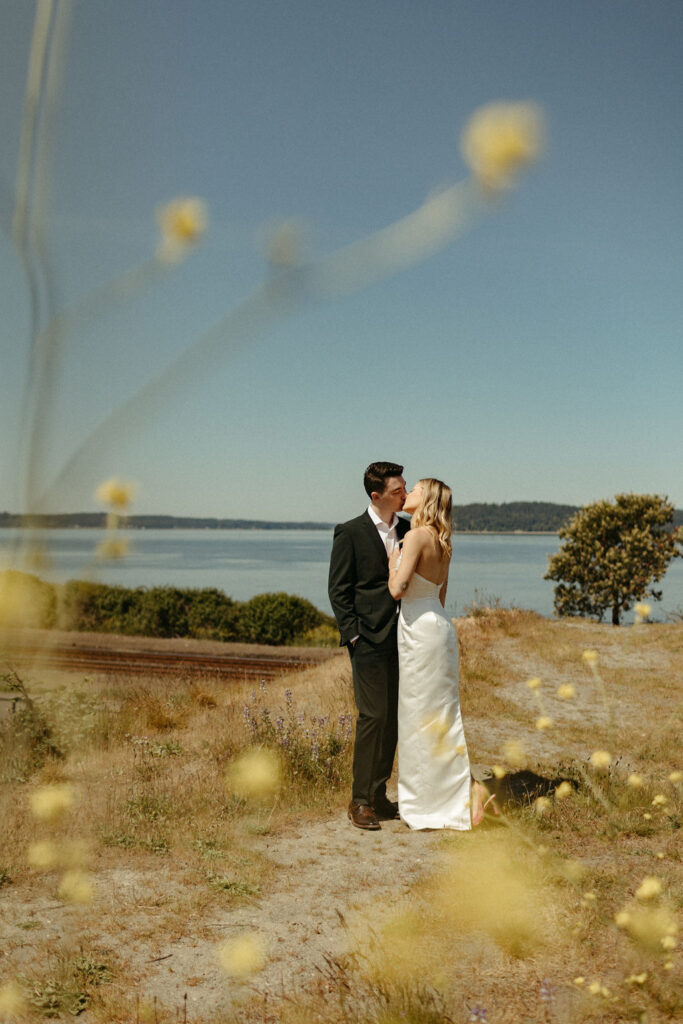 Bride and groom share a kiss overlooking a lake in Washington