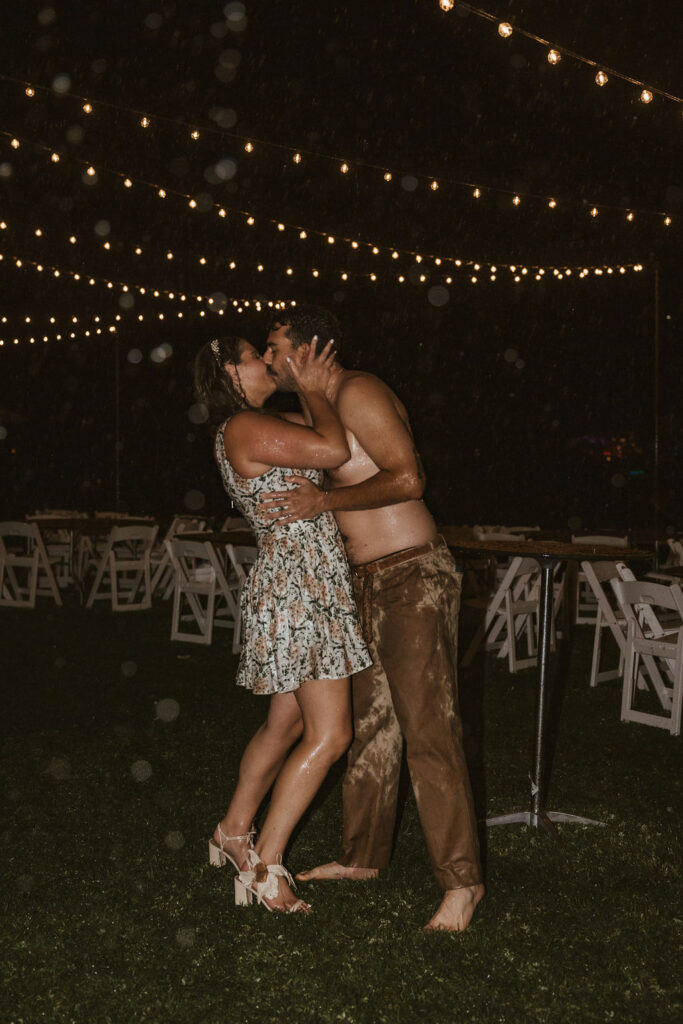 Bride and groom embrace during a torrential downpour during their wedding reception