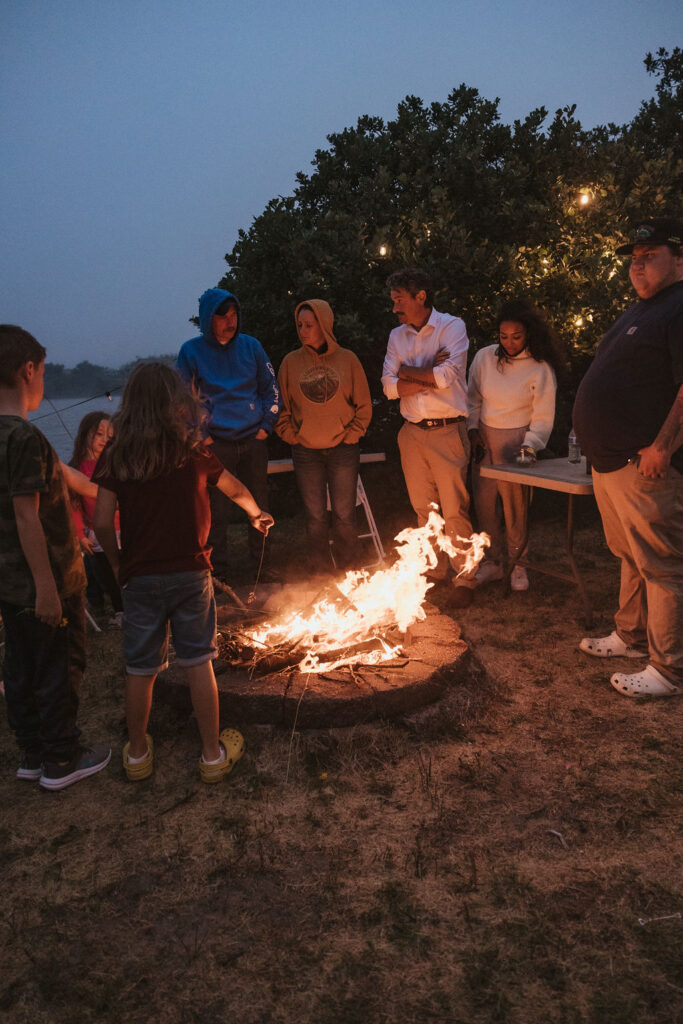 Guests gather around a bonfire following an intimate wedding day