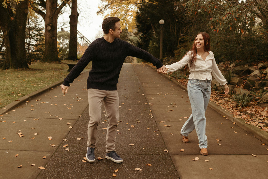 A couple frolics along a paved path during a beautiful Autumn morning in Cleveland, Ohio.